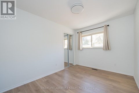 A room with a sliding glass door and a window with curtains.