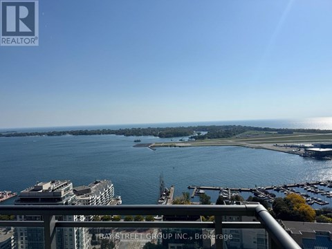 A view of a bay with boats and buildings from a balcony.
