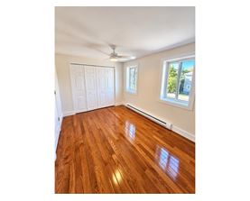 A room with wooden flooring and a ceiling fan.