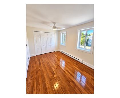 A room with wooden flooring and a ceiling fan.
