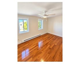 A room with wooden flooring and a ceiling fan.