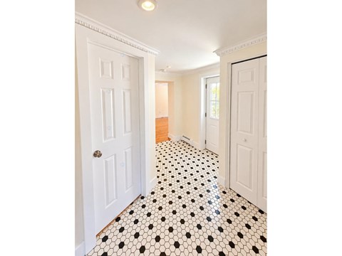A hallway with black and white tiles.