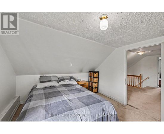 A bedroom with a bed and a nightstand.