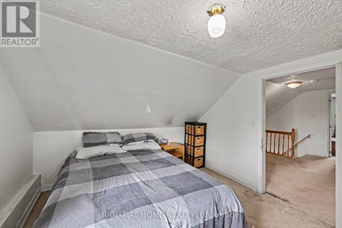 A bedroom with a bed and a nightstand.