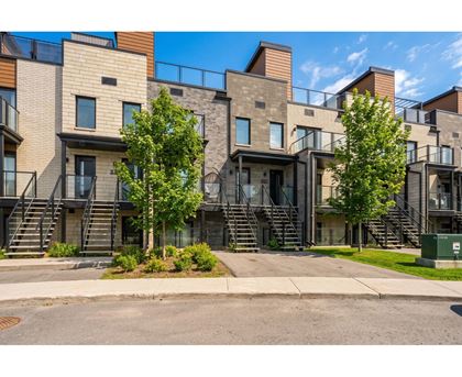 A modern apartment complex with a mix of brick and panel siding.