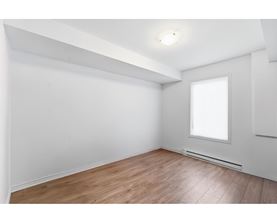 A room with a window and wooden flooring.