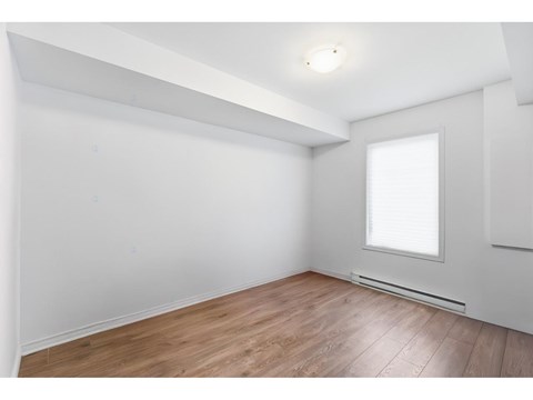 A room with a window and wooden flooring.