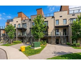 A modern apartment complex with a mix of stone and wood exteriors.