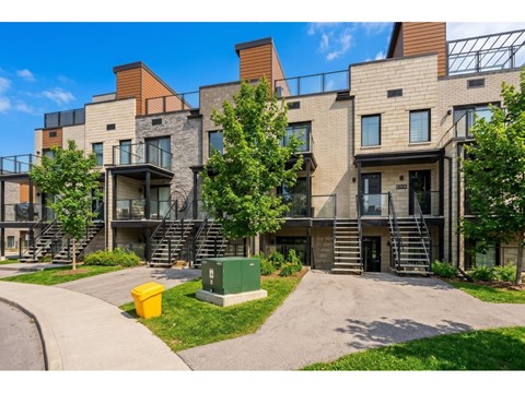 A modern apartment complex with a mix of stone and wood exteriors.