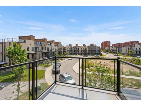 A balcony overlooks a road with cars and buildings.