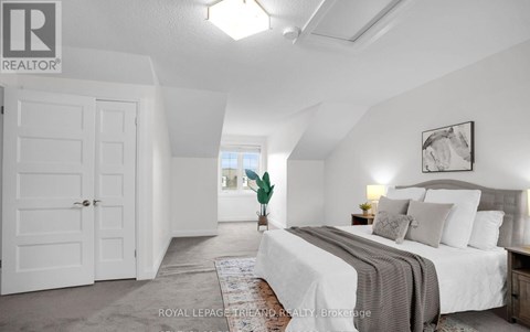 A bedroom with a large bed and a white door.