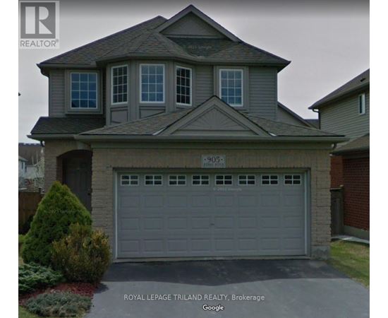 A house with a grey garage door and a sign that says "Royal LePage Trilland Realty, Brokerage".
