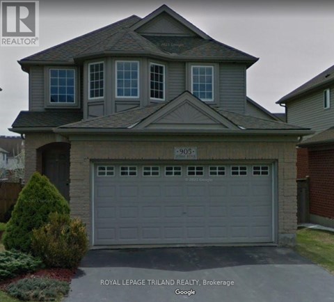 A house with a grey garage door and a sign that says "Royal LePage Trilland Realty, Brokerage".