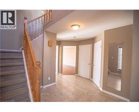 A spacious room with a staircase leading to the upper floor.