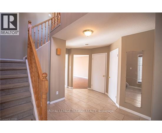 A spacious room with a staircase leading to the upper floor.