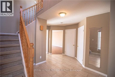 A spacious room with a staircase leading to the upper floor.