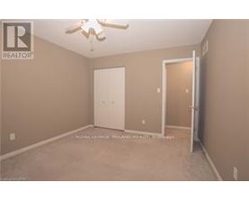 A bedroom with a ceiling fan and two doors.