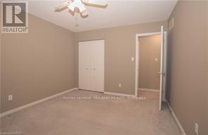 A bedroom with a ceiling fan and two doors.