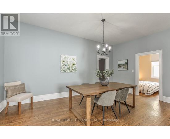 A dining room with a wooden table and chairs.