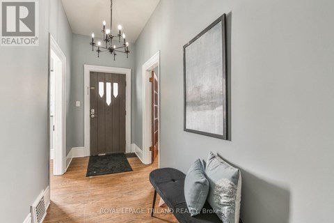 A hallway with a black bench and a framed picture on the wall.