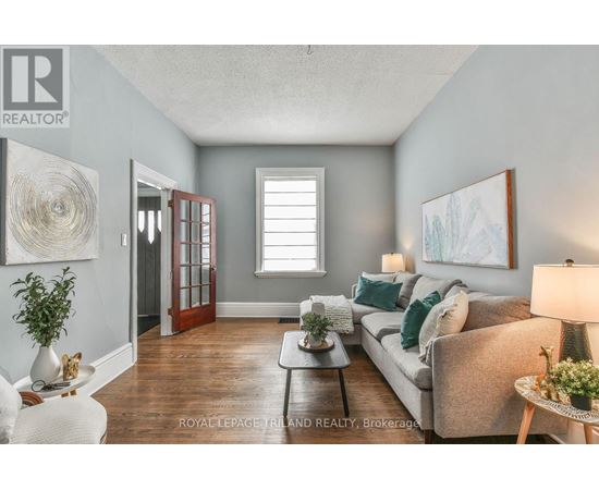 A living room with a couch, a coffee table, and a painting on the wall.