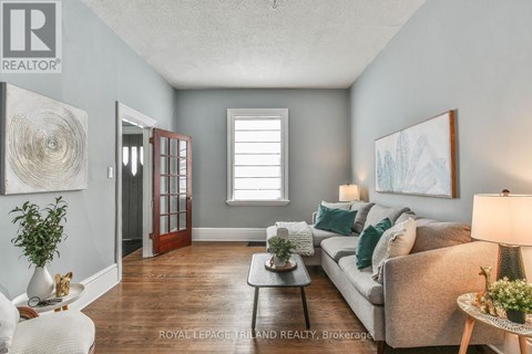 A living room with a couch, a coffee table, and a painting on the wall.