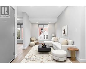 A modern living room with a white couch, a coffee table, and a large window.