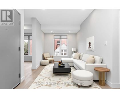 A modern living room with a white couch, a coffee table, and a large window.