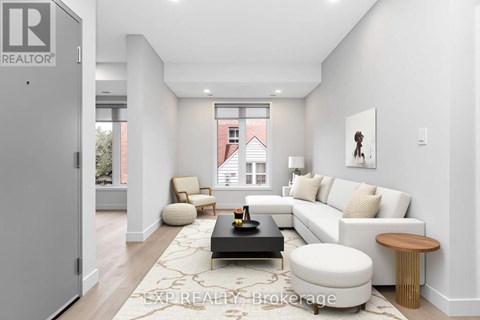 A modern living room with a white couch, a coffee table, and a large window.