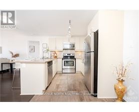 A modern kitchen with a refrigerator, oven, and microwave.