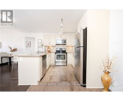 A modern kitchen with a refrigerator, oven, and microwave.