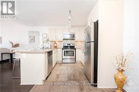 A modern kitchen with a refrigerator, oven, and microwave.