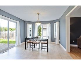 A dining room with a table and chairs.