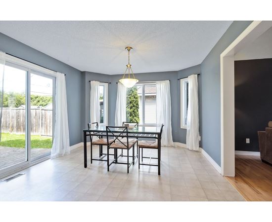 A dining room with a table and chairs.