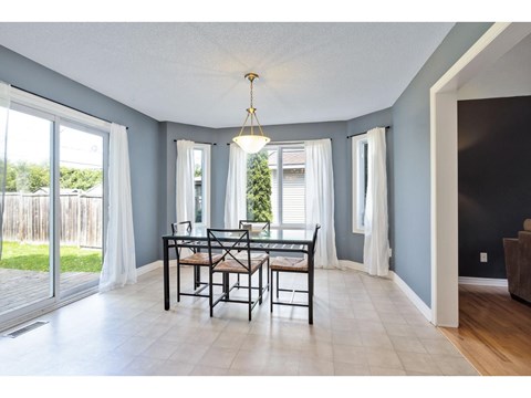 A dining room with a table and chairs.