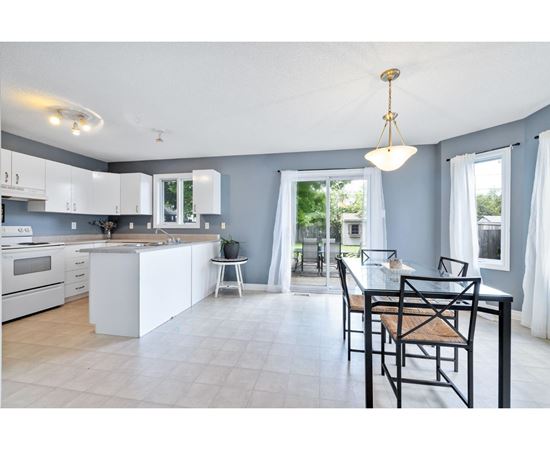 A kitchen with a table and chairs in the foreground.