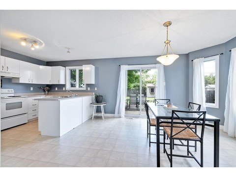 A kitchen with a table and chairs in the foreground.