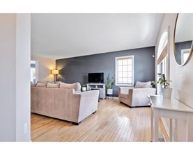 A living room with a couch, a chair, a table, and a television.