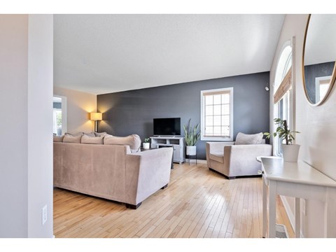 A living room with a couch, a chair, a table, and a television.