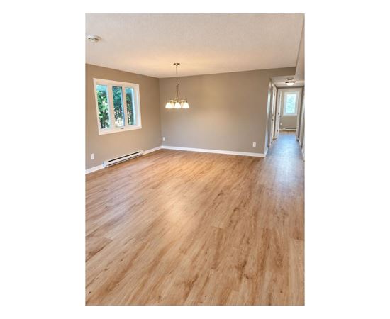 A room with wooden flooring and a chandelier.