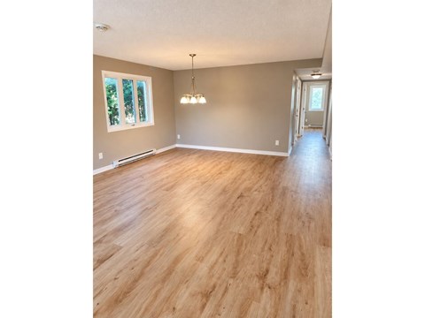 A room with wooden flooring and a chandelier.