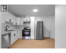 A modern kitchen with stainless steel appliances and white cabinets.