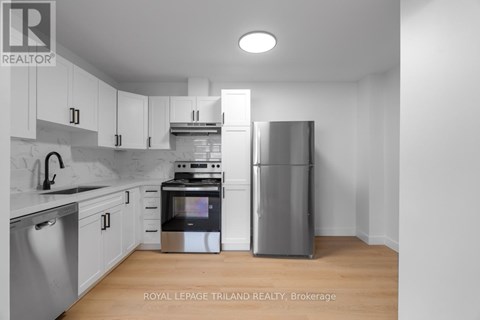 A modern kitchen with stainless steel appliances and white cabinets.