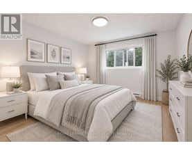 A bedroom with a large bed, a window with curtains, and a nightstand with a lamp.