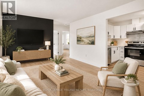A modern living room with a flat screen TV, a sofa, a coffee table, and a painting on the wall.
