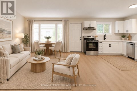 A well-lit, modern kitchen and living room with white furniture and a wooden coffee table.