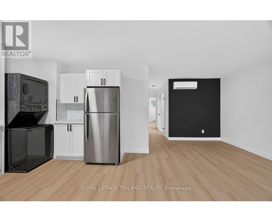 A kitchen with a black fridge and a white fridge.
