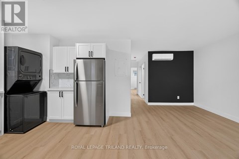 A kitchen with a black fridge and a white fridge.
