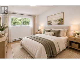 A bedroom with a large bed and a painting on the wall.