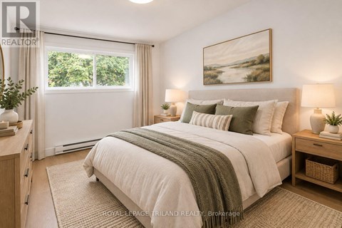 A bedroom with a large bed and a painting on the wall.
